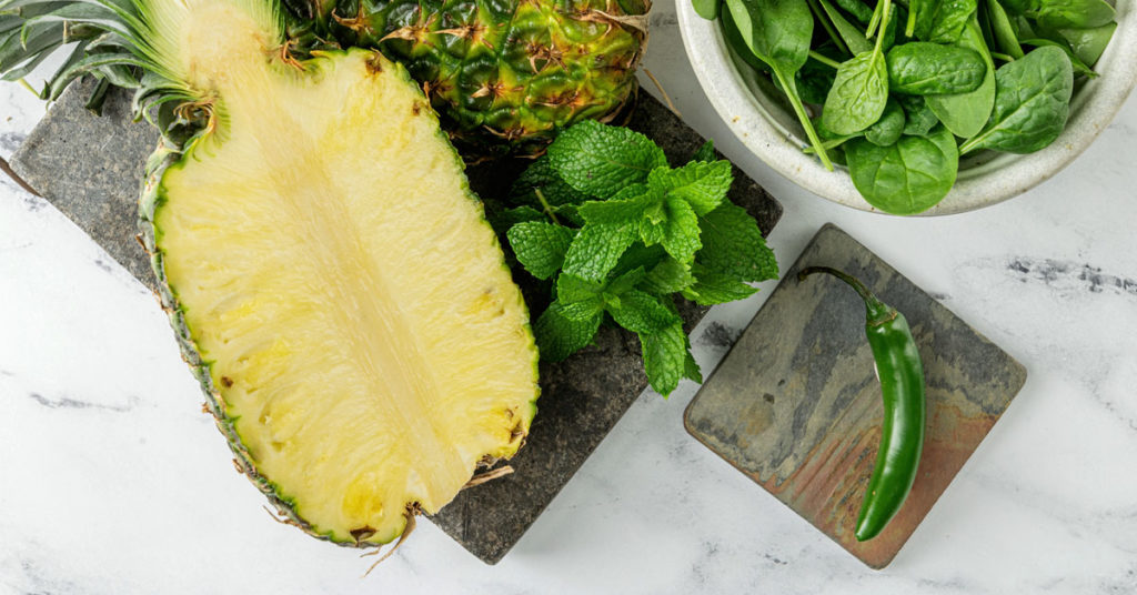 Ingredients to make spicy pineapple juice recipe on a marble counter