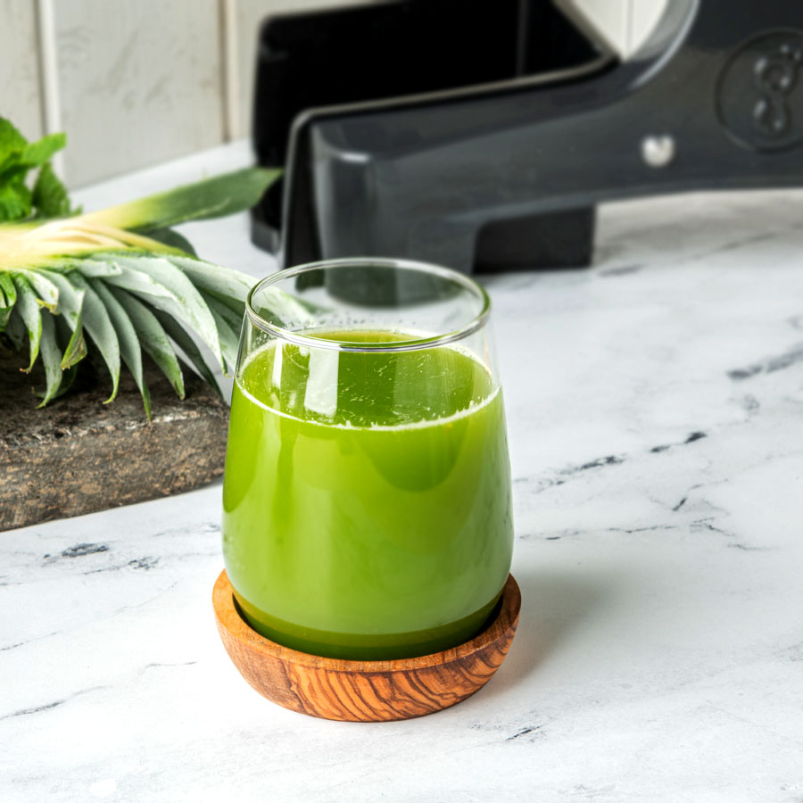 one glass of green juice on a marble counter