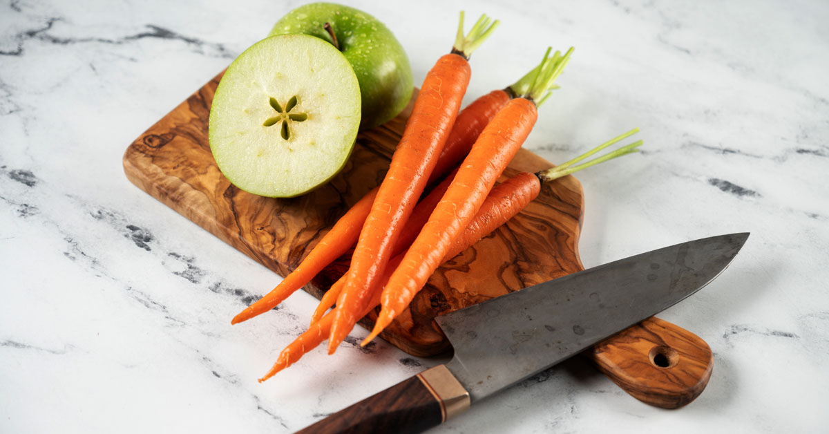 carrots and apples on a cutting board