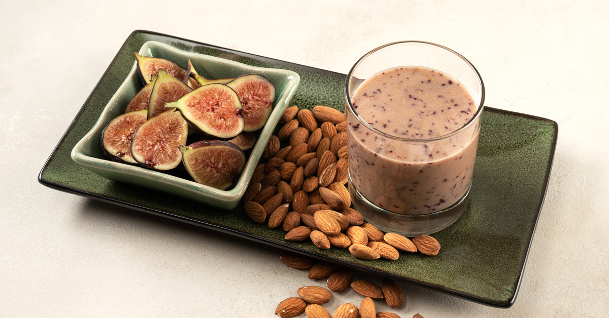 fig milk on a green plate surrounded by almonds
